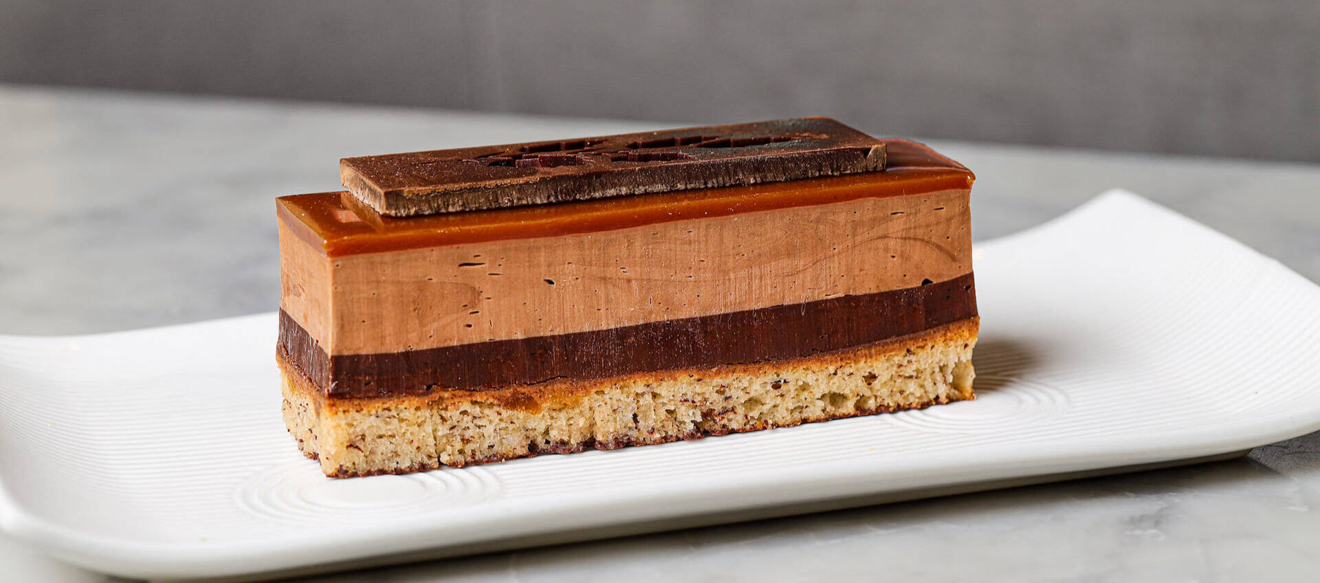 A signature layered chocolate pastry handcrafted by Praliné Patisserie